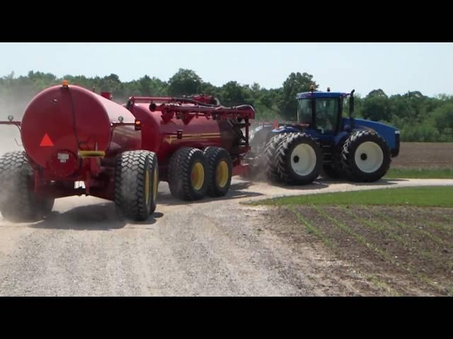 New Holland Articulating Tractor Spreading Manure with a Nuhn Quad Train