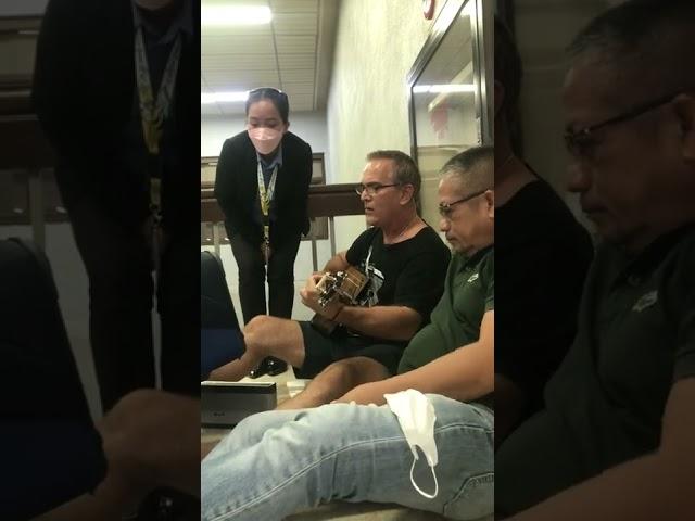 Foreign passenger Play his guitar while waiting for his flight