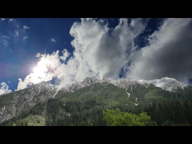 Fast moving clouds across the sky in the mountains. Video screensaver - mountains and moving clouds.