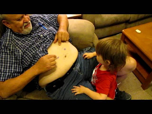 Baby plays with Grandpa's Belly button with face