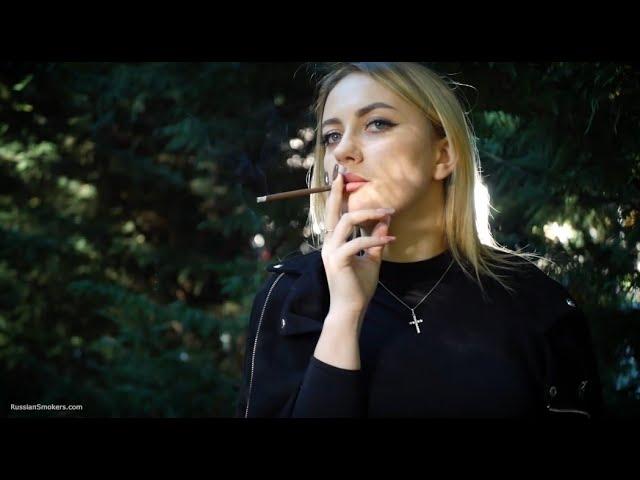 Alina is smoking brown 120mm cigarette in the park