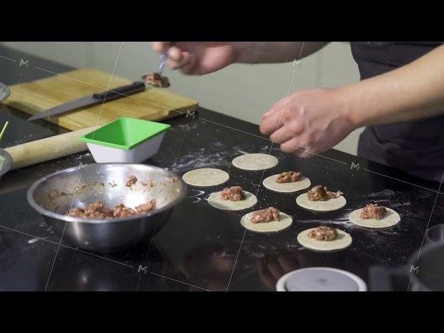 Cook putting minced meat on dough. Art. Close-up of professional chef applying minced meat for