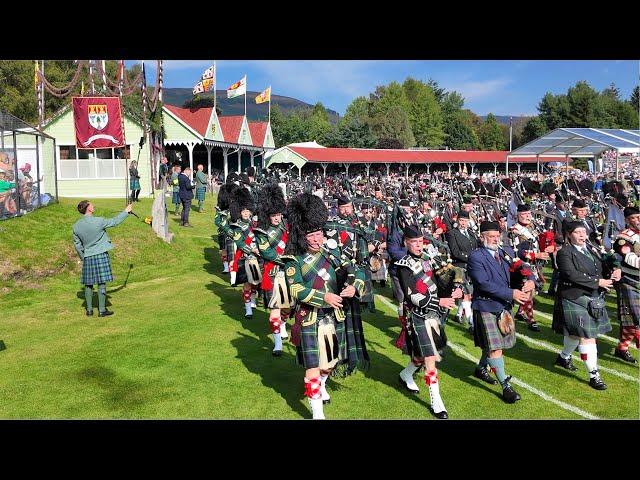 Massed Pipes & Drums Games field march with Atholl Highlanders at 2024 Braemar Gathering in Scotland