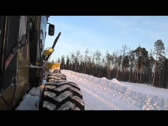 Grader cleans snow. Автогрейдер CAT убирает снег.   採点者は雪を取り除きます