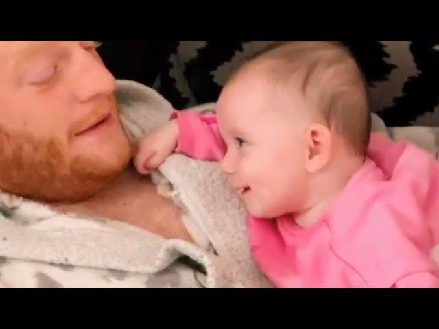 Baby girl smiles sleepily at dad while trying to stay awake || WooGlobe