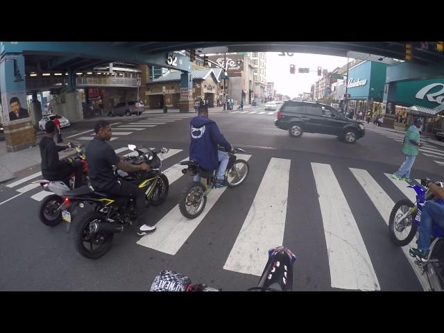 Guy wheelies a Street Bike past a cop