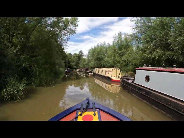 Navigating on the Oxford canal through Thrupp in a narrow boat.