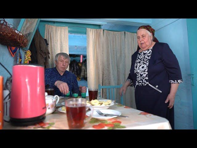 Happy elderly couple lives in the taiga forest far from civilization. Life in Russian villages