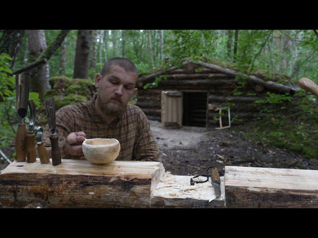 woodworking in dugout at heavy rain , making kuksa , no talking