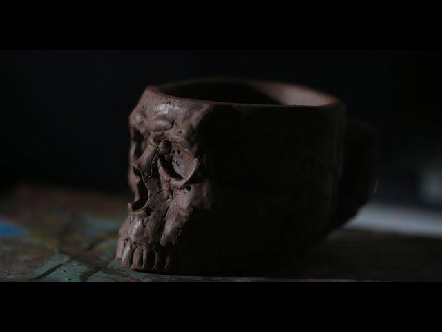 Hand building a skull coffee mug with water clay