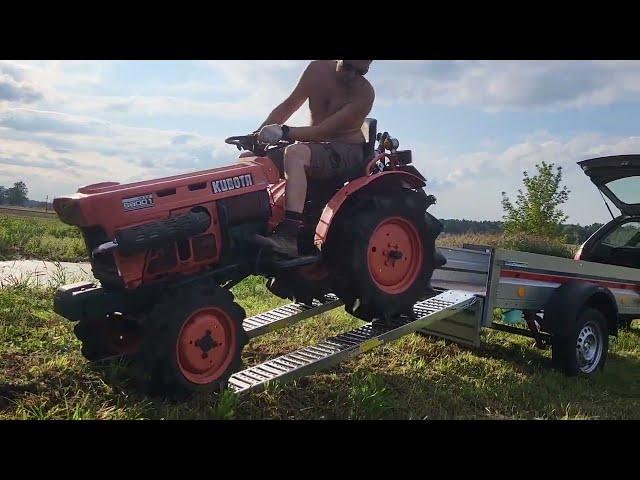 Compact tractor Kubota B6001 driving to trailer for transportation