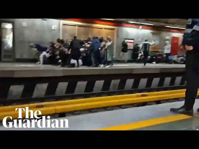 People run for cover as Iranian police open fire during protest at Tehran metro station