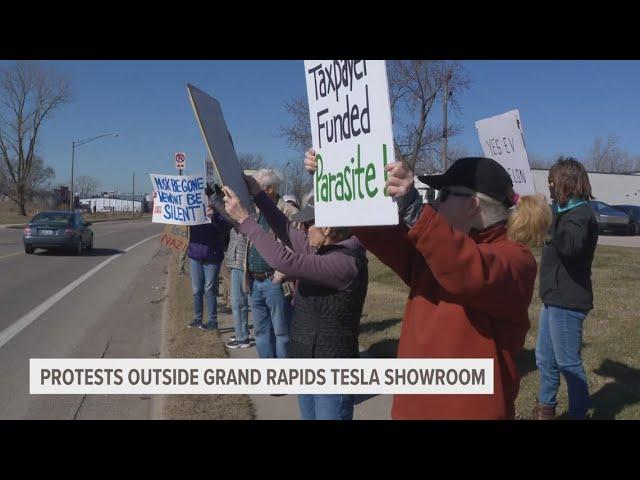 Dozens gather outside Tesla showroom in Grand Rapids to protest Musk, DOGE