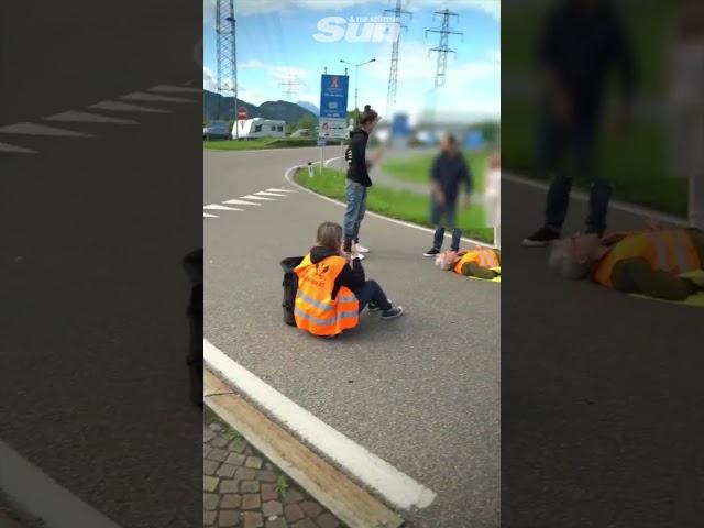 Eco protester knocked to the floor by car at protest