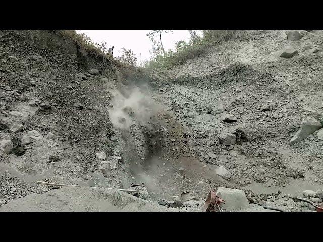 The fall of dry sand from the top of the cliff creates a cloud of smoke