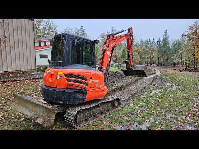 Rock wall footing and ditch cleaning with the Kubota KX 040 4