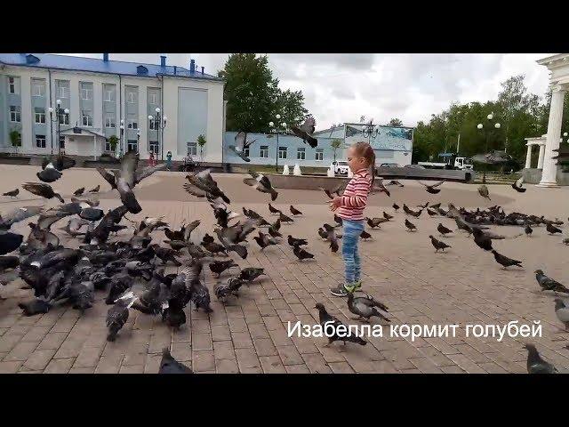 Изабелла кормит голубей с рук.