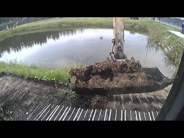 Экскаватор в работе: откосы пруда, планировка, обочины. Excavator at work.