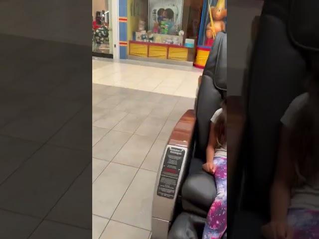 Little girl sitting in massage chair