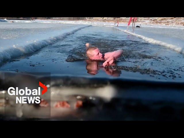 Siberian enthusiasts plunge into ice-cold river to kick off winter swimming season