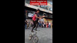 Catching Fire: A Torch Juggler's Performance on Leicester Square in London