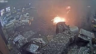 Foundry worker puts wet scrap metal in furnace