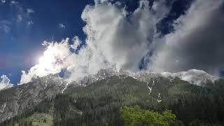 Fast moving clouds across the sky in the mountains. Video screensaver - mountains and moving clouds.