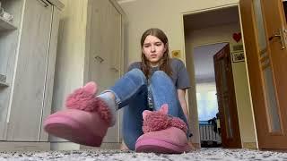 Girl taking off pink slippers and gray socks to show soles