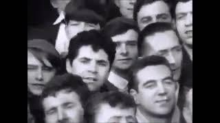 Liverpool fans on the Kop sing ‘She Loves You’ by The Beatles in 1964.