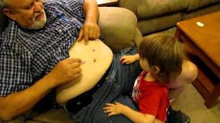 Baby plays with Grandpa's Belly button with face