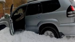 Toyota LandCruiser Prado 120 leaving the parking through the snow