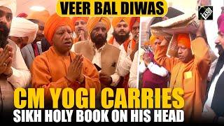 CM Yogi Adityanath walks with palanquin carrying Sikh holy book on his head on Veer Bal Diwas