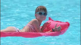 Niña en bikini en la piscina.