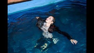 cute girl in wet jeans and a wet denim jacket in the pool