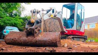 Mini digger clearing an overgrown garden Takeuchi TB216 Excavator