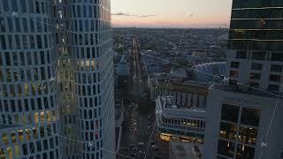 High angle view of straight street in urban borough. Backwards reveal of modern high rise hotel