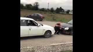 Strong man in between 2 cars 