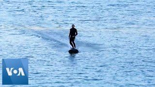 Surfer Rides Electric Board on Bilbao River to Promote Eco-Friendly Mobility