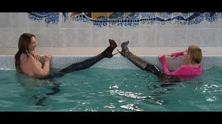 A WETLOOK of GIRLS in leggings, boots and heels in the pool !