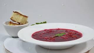 Red Borsch with meat in plate. A delicious red borscht with sour cream and herbs on a white plate