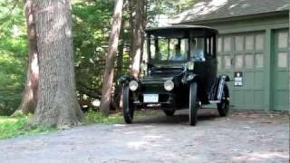 1914 Detroit Electric car drives silently away from its garage