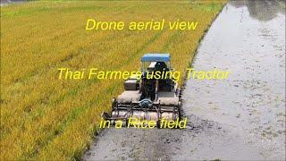 Thai farmers using tractor in a rice field in Thailand.