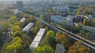 Aerial footage of busy railway tracks in urban borough. Tilt up reveal of cityscape. Berlin, Germany