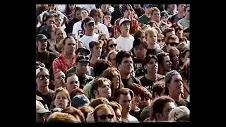 MM playing an outdoor festival. NIN band members sitting on side of stage.