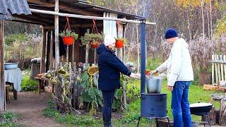 Happy family builds a house far from civilization. Cooking Uzbek pilaf on an outdoor stove