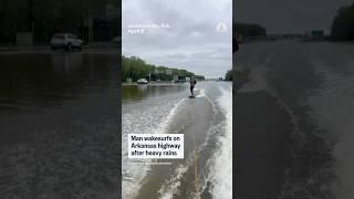 Man wake surfs on Arkansas highway after heavy rains