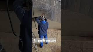 Prindere folie termoizolanta din aluminiu pe acoperis la o cabana de lemn in forma de A