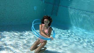 Carla swimming underwater with Hula Hoops