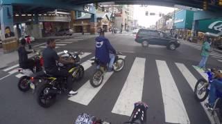 Guy wheelies a Street Bike past a cop