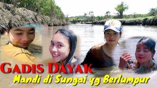 Gadis Dayak mandi di sungai dan menangkap ikan di lumpur